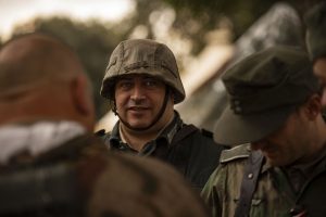 Hombre con casco militar participando en una recreación de la Segunda Guerra Mundial.