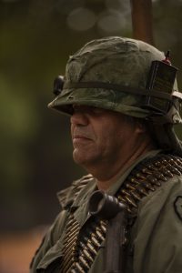 Soldado moderno reflexionando durante recreación bélica