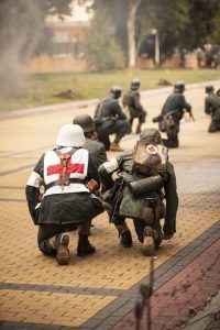 Sanitario alemán agachado durante recreación de batalla histórica