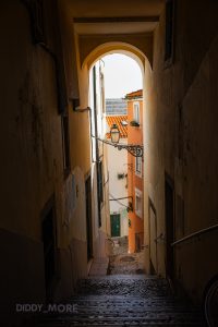 Callejón empedrado con arco y fachadas coloridas en Lisboa, Portugal