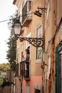 Músico callejero tocando el acordeón en un balcón del barrio de Alfama en Lisboa