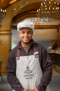 Trabajador de la Fábrica da Nata en Lisboa con uniforme tradicional y fondo de la pastelería