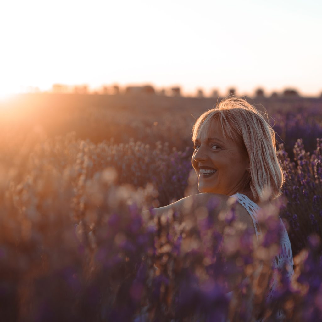 Sonrisa entre lavandas al atardecer Mujer sonriendo entre campos de lavanda al atardecer en verano.