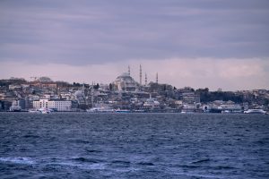 Vista de Estambul desde el Bósforo con mezquitas y edificios históricos bajo cielo nublado

