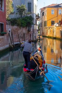 Góndola navegando un canal tranquilo de Venecia al atardecer