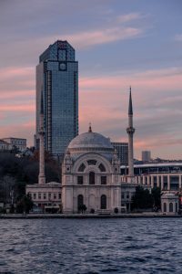 Mezquita de Ortaköy con el edificio Süzer Plaza de fondo al atardecer en Estambu