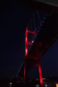 Puente del Bósforo iluminado en rojo durante la noche en Estambul