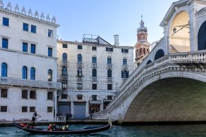 Góndola navegando frente al puente de Rialto en Venecia, Italia.
