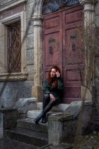Mujer sentada junto a una puerta de piedra en el centro histórico de Verona
