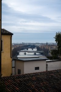 Panorámica del río Adigio en Verona al atardecer, capturada desde un mirador elevado con vista a los puentes y tejados de la ciudad